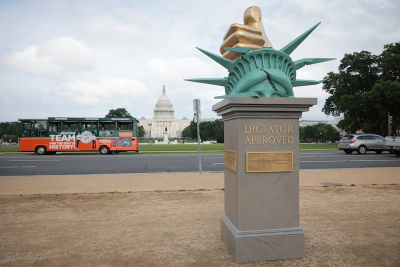 A wide shot of the "Dictator Approved" art installation with the Capitol building in the background.