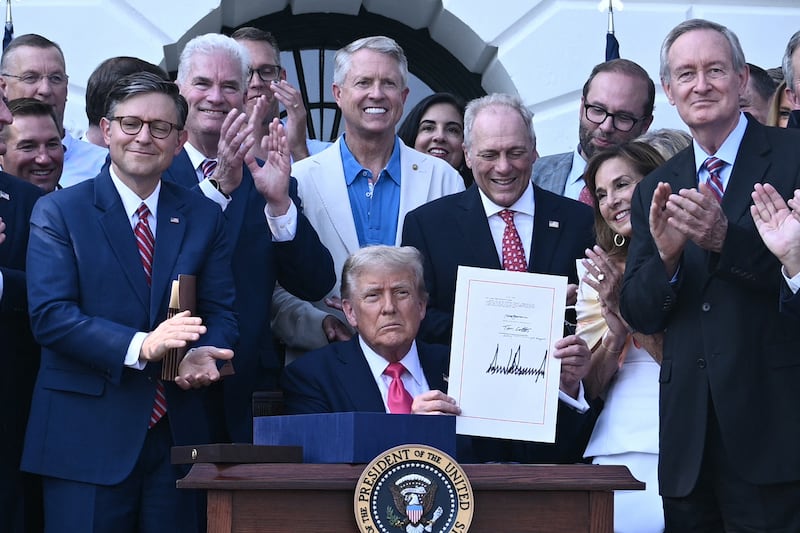 TOPSHOT - US President Donald Trump (C) shows his signature on the "Big Beautiful Bill Act" at the White House in Washington, DC, on July 4, 2025. US President Donald Trump signed his flagship tax and spending bill on July 4 in a pomp-laden Independence Day ceremony featuring fireworks and a flypast by the type of stealth bomber that bombed Iran. Trump pushed Republican lawmakers to get his unpopular "One Big Beautiful Bill" through a reluctant Congress in time for him to sign it into law on the US national holiday -- and they did so with a day to spare Thursday. (Photo by Brendan SMIALOWSKI / POOL / AFP) (Photo by BRENDAN SMIALOWSKI/POOL/AFP via Getty Images)