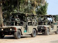 Israeli soldiers drive in military vehicles by Israel's border with Gaza in southern Israel, October 10, 2023.