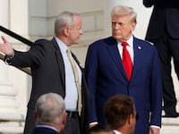 Former U.S. President Donald Trump (R) observes a changing of the guard at the Tomb of the Unknown Soldier at Arlington National Cemetery.