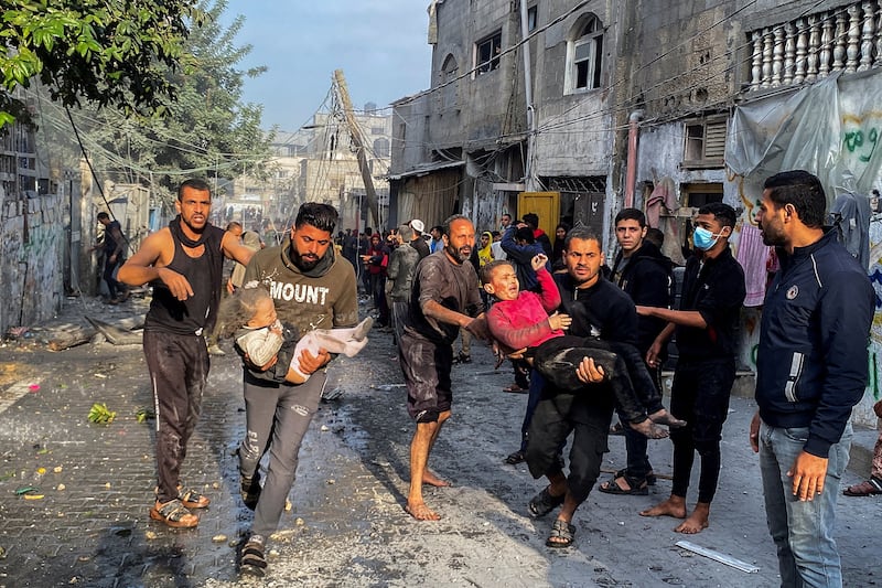 Palestinians carry wounded children following an Israeli strike on a house in Rafah.