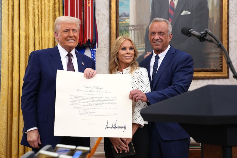 President Donald Trump, Robert F. Kennedy Jr., and Kennedy's wife Cheryl Hines pose after Kennedy was sworn in as Secretary of Health and Human Services in the Oval Office at the White House on February 13, 2025 in Washington, DC.