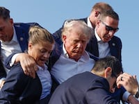 Donald Trump is swiftly escorted off stage by Secret Service agents after a 20-year-old gunman opened fire at him.