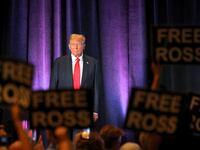 Supporters of jailed Silk Road founder Ross Ulbricht hold placards as Donald Trump addresses Libertarian Party convention in D.C.