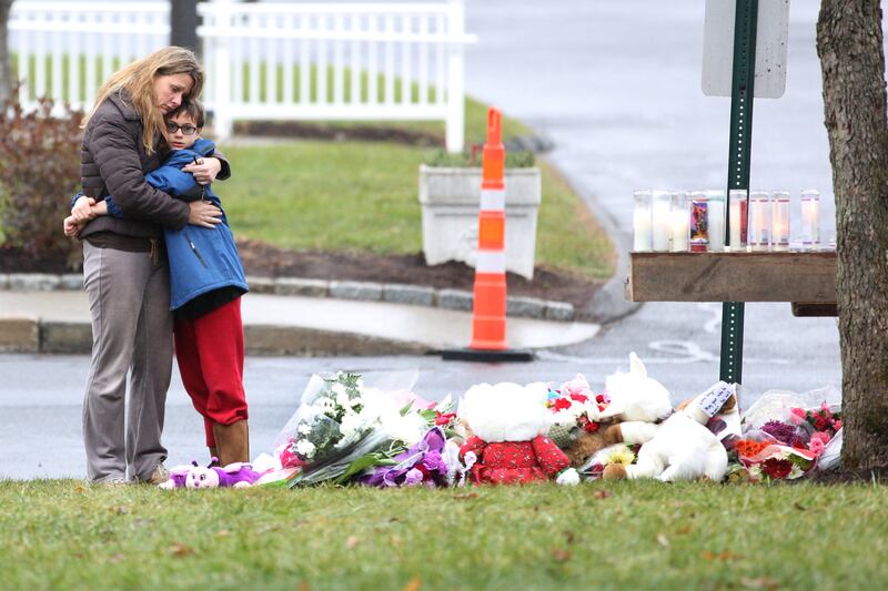 Kady Vales hugs her son Mason, 10, outside the shrine for the victims at St. Rose of Lima Church in Sandy Hook after the mass shootings at Sandy Hook Elementary School, Newtown, Connecticut, USA. 16th December 2012. Photo Tim Clayton (Photo by Tim Clayton/Corbis via Getty Images)