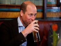 Britain's William, Prince of Wales drinks a pint of cider as he chats to local business people inside the Dog and Duck pub in Soho ahead of King Charles' coronation, in London, May 4, 2023.