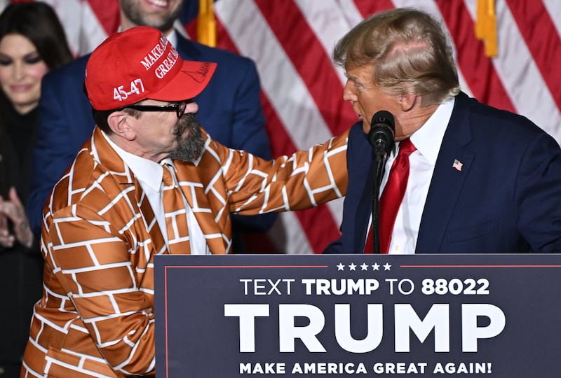 Former US President and Republican presidential hopeful Donald Trump greets supporter Blake Marnell at a watch party during the 2024 Iowa Republican presidential caucuses in Des Moines, Iowa, on January 15, 2024. Trump told Americans Monday "it is time for our country to come together" after he won the Iowa caucuses, cementing his status as the likely Republican challenger to take on President Joe Biden in November's election. (Photo by Jim WATSON / AFP) (Photo by JIM WATSON/AFP via Getty Images)