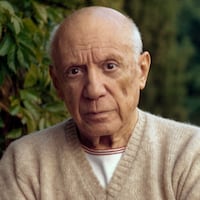 MOUGINS, FRANCE - 1966 : Pablo Picasso standing by a green fern with folded arms, wearing a cashmere sweater. (Photo by Tony Vaccaro / Getty Images)