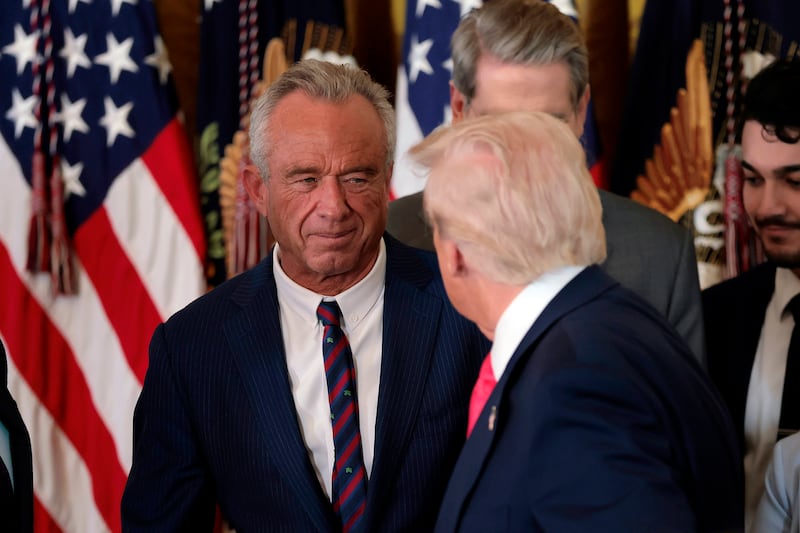 WASHINGTON, DC - NOVEMBER 13: President Donald Trump, shakes hands with Health and Human Services Secretary Robert F. Kennedy Jr. alongside Secretary of Housing and Urban Development Scott Turner (L) after Trump signed the "Fostering the Future" executive order the East Room of the White House on November 13, 2025 in Washington, DC. The executive order, championed by first lady Melania Trump, works to expand opportunities for education, career development, housing and other resources for youth transitioning from foster care to adulthood. (Photo by Heather Diehl/Getty Images)