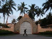 A man walks past the main gate of Mar-a-Lago