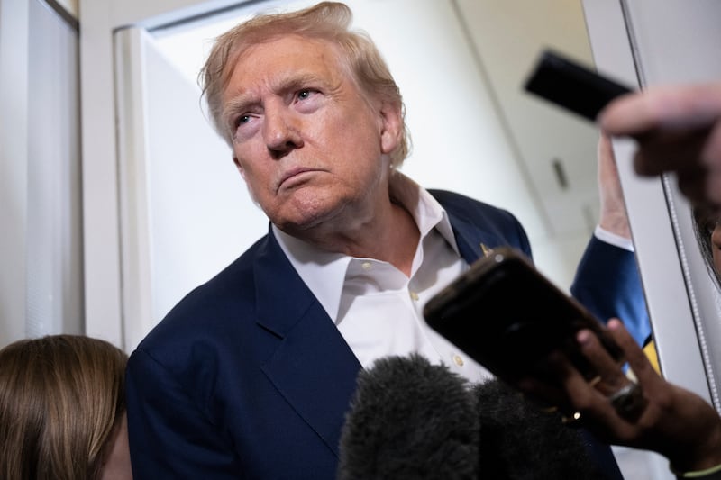 US President Donald Trump listens to questions from reporters aboard Air Force One over the United Kingdom on July 29, 2025, as he returns to Washington following a trip to Scotland.