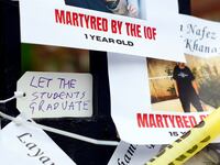Fliers with the names and photos of Palestinians killed by Israeli forces are attached to Johnston Gate outside of Harvard. Harvard Out of Occupied Palestine held an emergency rally.
