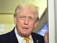US President Donald Trump speaks with reporters aboard Air Force One