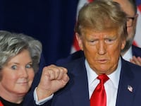 Trump stands on stage next to Susie Wiles.