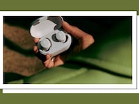 Hand holding a pair of Bose wireless bluetooth earbuds, available at QVC