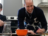 Prince William, Prince Of Wales smiles as he looks up while decorating biscuits during his visit to WEST, a new OnSide Youth Zone WEST on March 14, 2024 in London, England.