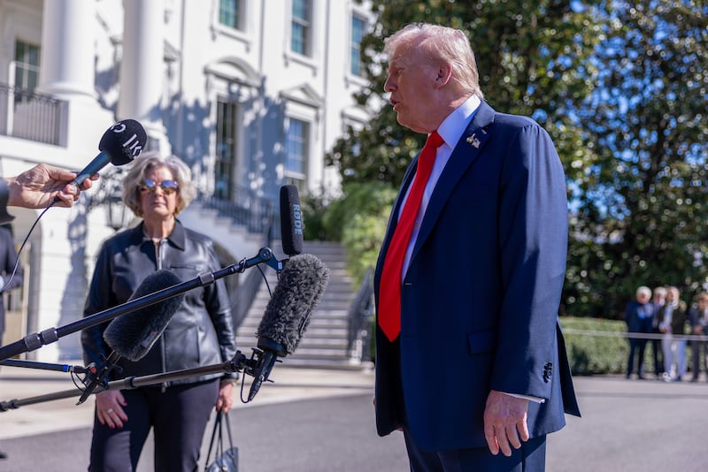 White House Chief of Staff Susie Wiles listens as U.S. President Donald Trump talks to the media.