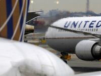 United Airlines planes taxi on a busy runway.