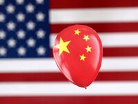 A printed balloon with Chinese flag is placed on a U.S. flag.