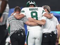 Aaron Rodgers #8 of the New York Jets is helped off the field after suffering an apparent injury after being sacked by Leonard Floyd #56 of the Buffalo Bills during a game at MetLife Stadium on September 11, 2023 in East Rutherford, New Jersey.