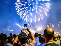 Spectators view (real) fireworks marking the July Fourth holiday at Brooklyn Bridge Park in New York City on July 4, 2025.