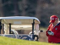 A photo of Donald Trump typing something on his cellphone while on the golf course.