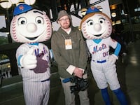 John Wilson poses with Mr and Mrs Met at Mets Stadium.