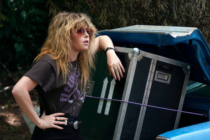 Natasha Lyonne leans against boxes in a still from ‘Poker Face’