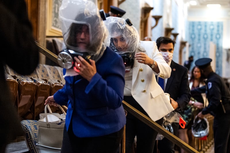UNITED STATES - JANUARY 6 (FILE): Reps. Sara Jacobs, D-Calif., center, and Annie Kuster, D-N.H., left, take cover as rioters attempt to disrupt the joint session of Congress to certify the Electoral College vote on Wednesday, January 6, 2021. (Photo By Tom Williams/CQ-Roll Call, Inc via Getty Images)
