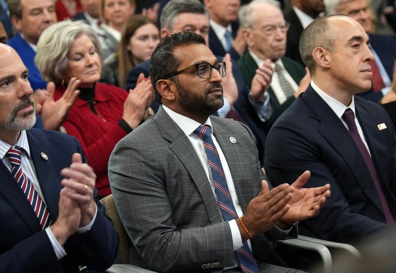 FBI Director Kash Patel applauds as Donald Trump speaks at the Justice Department.