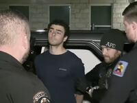 A man being escorted by police.