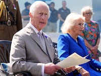 King Charles III makes a statement to members of the Alderney island with Britain's Queen Camilla.