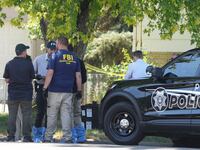 FBI officials and other law enforcement officers stand outside the home of Craig Robertson who was shot and killed by the FBI in a raid on his home on August 9, 2023 in Provo, Utah.