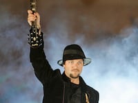 Bam Margera, a professional skateboarder and television personality, holds up a guitar before smashing it.