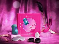 Lovense Lover Set displayed with toys and accessories including vibrator, massager, feather tickler, blindfold, and wrist cuffs in a romantic Valentine’s Day setting