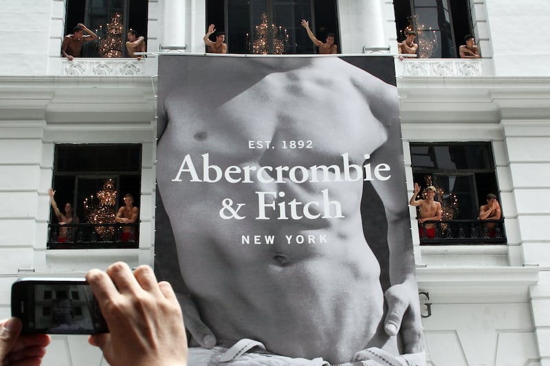 A man uses his mobile phone to take photographs of topless male models waving to a crowd of onlookers from the soon to open Abercrombie & Fitch flagship clothing store in Hong Kong on August 5, 2012. The store is due to be opened for trading on August 11. AFP PHOTO / LAURENT FIEVET (Photo credit should read LAURENT FIEVET/AFP/GettyImages)