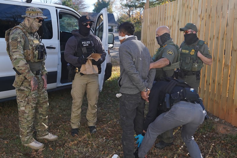 A person is detained by U.S. Border Patrol agents after being apprehended inside a fast food restaurant