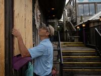 A man places plywood in front of a store ahead of the arrival of Hurricane Idalia in Cedar Key, Florida, Aug. 29, 2023.