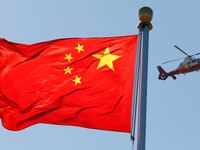 A China Central Television (CCTV) helicopter flies over the Chinese national flag in Tiananmen Square October 9, 2012.