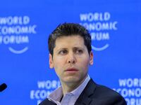 Sam Altman in front of a World Economic Forum sign