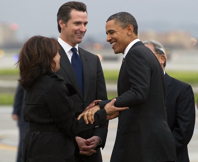 US President Barack Obama greets California Attorney General Kamala Harris (L) and Gavin Newsom, Lieutenant Governor of California, after arriving on Air Force One at San Francisco International Airport in San Francisco, California, February 17, 2011. Obama is traveling on a two-day trip to the West Coast, where he will meet with technology business leaders in California and tour an Intel plant in Oregon. AFP PHOTO / Saul LOEB (Photo credit should read SAUL LOEB/AFP via Getty Images)