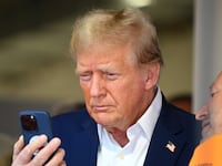 MIAMI, FLORIDA - MAY 05: Donald Trump talks on the phone in the McLaren garage prior to the F1 Grand Prix of Miami at Miami International Autodrome on May 05, 2024 in Miami, Florida. (Photo by Clive Mason/Getty Images)