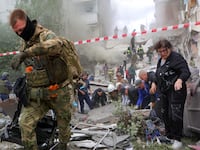 People remove debris while searching for survivors following the collapse of a section of an apartment block in the city of Belgorod, Russia, May 12, 2024.