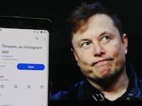A man shows the newly introduced ''Threads'' app with an Elon Musk background. Meta CEO Mark Zuckerberg, who launched Threads, trolled Musk in his first tweet since 2012 with a meme referencing the new platform.