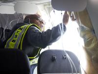 National Transportation Safety Board (NTSB) investigator-in-charge John Lovell examines the fuselage plug area of Alaska Airlines Flight 1282 Boeing 737-9 MAX in Portland, Oregon, Jan. 7, 2024.
