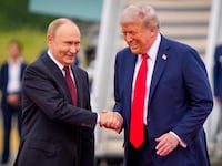 President Donald Trump (R) greets Russian President Vladimir Putin