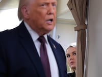 White House Press Secretary Karoline Leavitt listens to U.S. President Donald Trump speak to reporters on board Air Force One