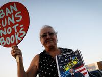 A woman holds a sign during a gathering outside a Books-a-Million bookstore where Florida Gov. Ron DeSantis is expected to sign copies of his book “The Courage to Be Free” in Leesburg, Florida, Feb. 28, 2023.