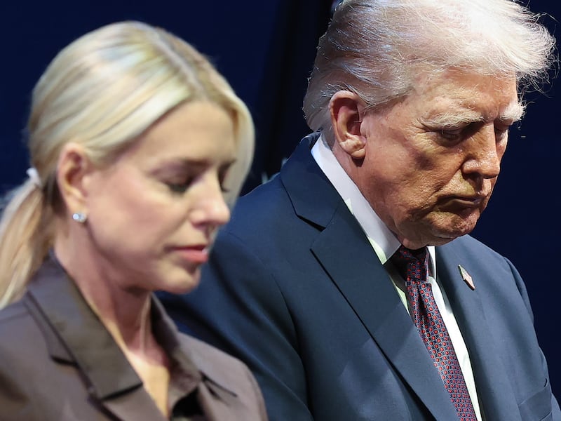 President Donald Trump bows his head in prayer with Attorney General Pam Bondi at the Museum of the Bible.