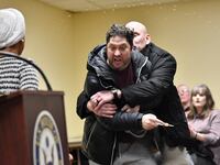 A man is tackled after spraying an unknown substance at US Representative Ilhan Omar (D-MN) (L) during a town hall she was hosting in Minneapolis, Minnesota, on January 27, 2026. (Photo by Octavio JONES / AFP via Getty Images)